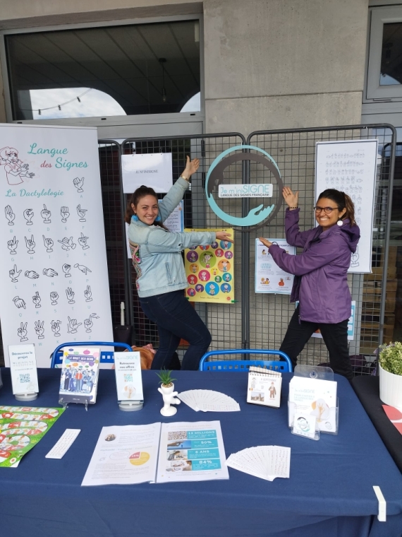 Lucie et Nathalie posent derrière leur stand HandiBron